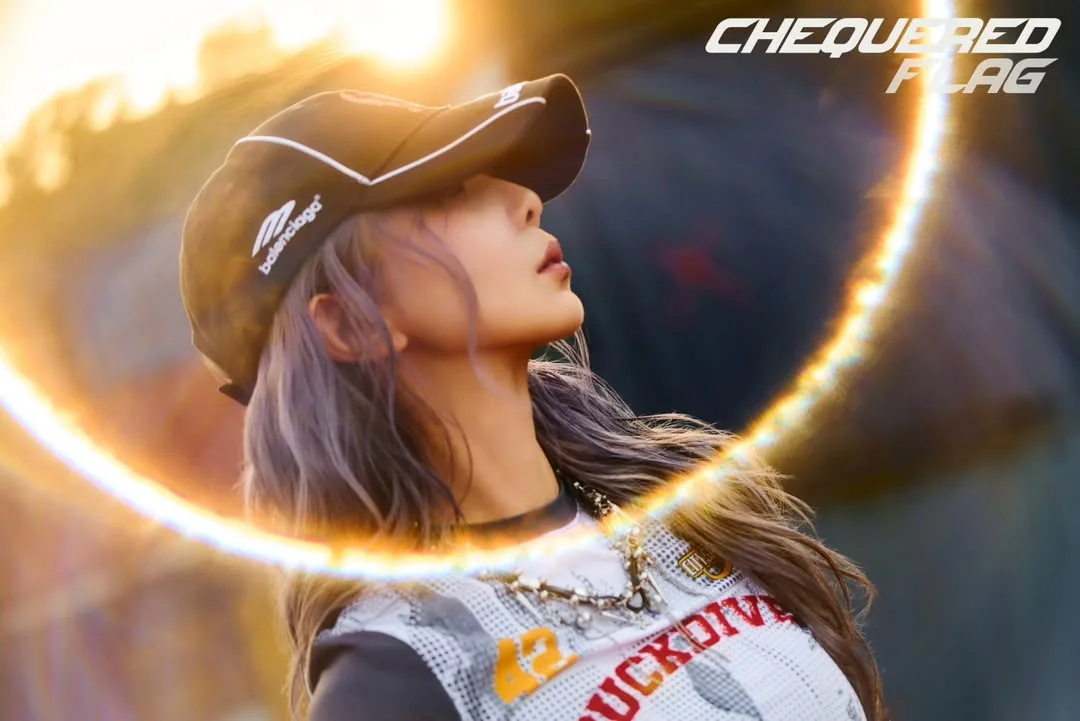 Dami in a baseball hat and shit looking to the side with a lens flare in front.