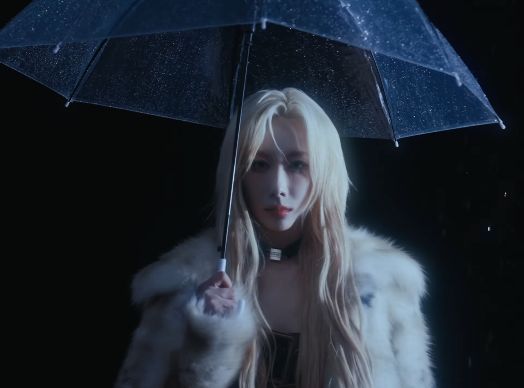 Handong in a fur coat top and umbrella as the rain falls upwards.