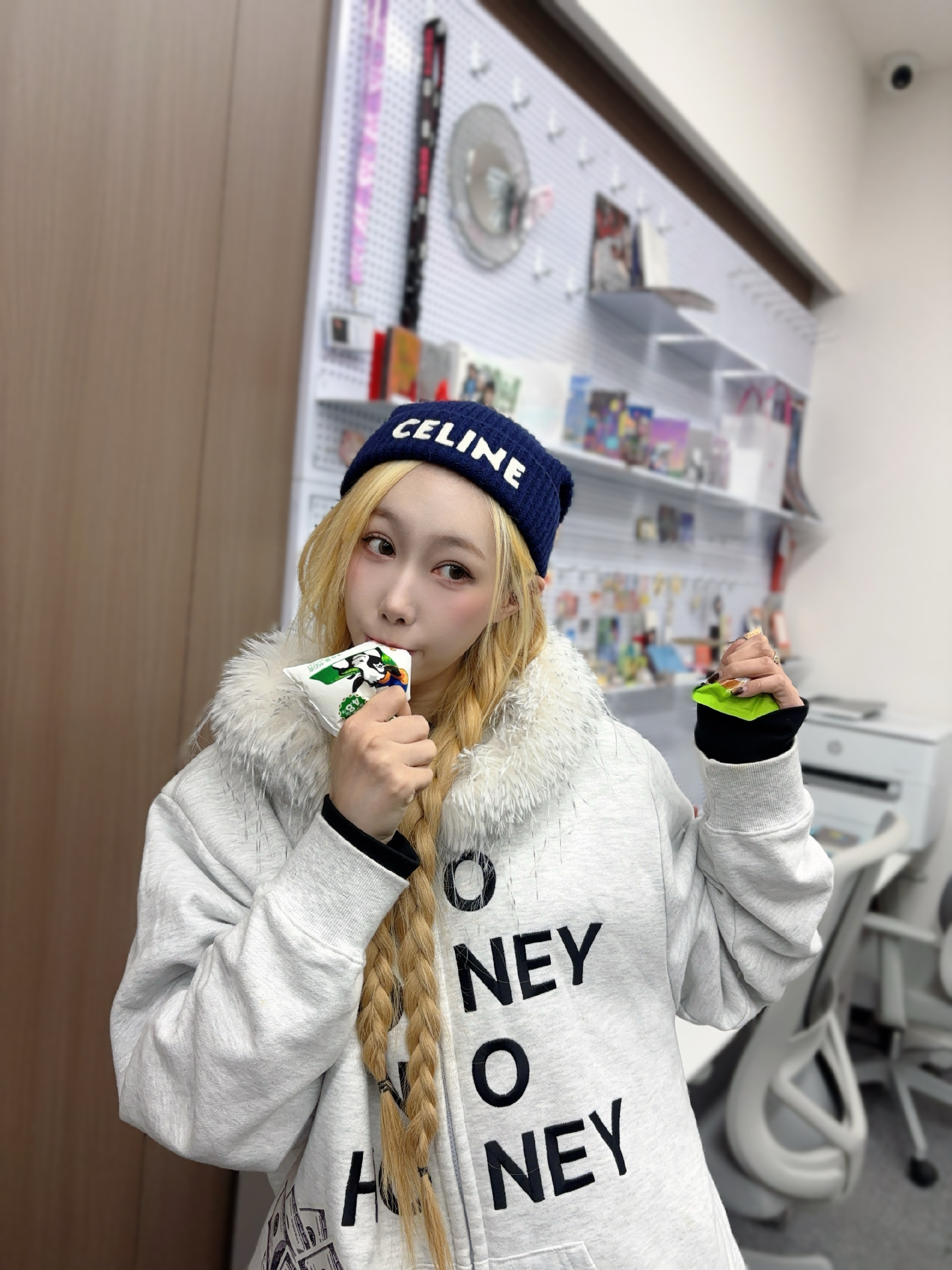 Handong in a white sweatshirt biting into something for the camera.