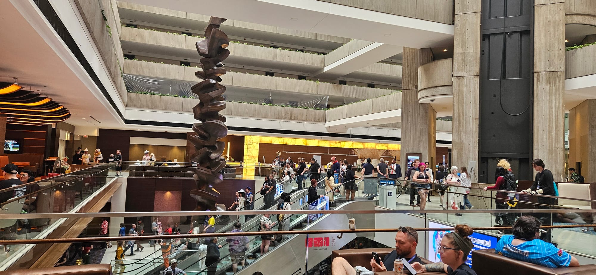 A wide shot view of the Hyatt Regency O'Hare second floor lobby, with people in and around the area.