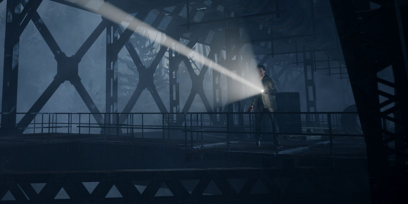 Alan Wake on a steel bridge with a flashlight shining out into the darkness.