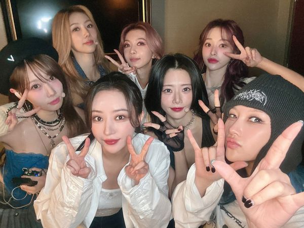 Dreamcatcher forms victory signs and rocker horns taking a group photo.