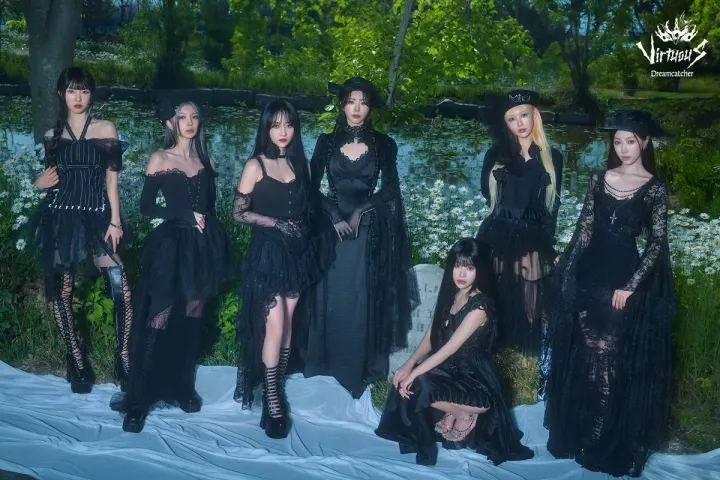 Dreamcatcher dressed in all-black against a background of a river with a gravestone.