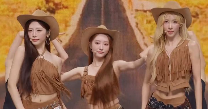JiU, SuA, and Yoohyeon dressed in brown suede and cowboy hats for their performance.