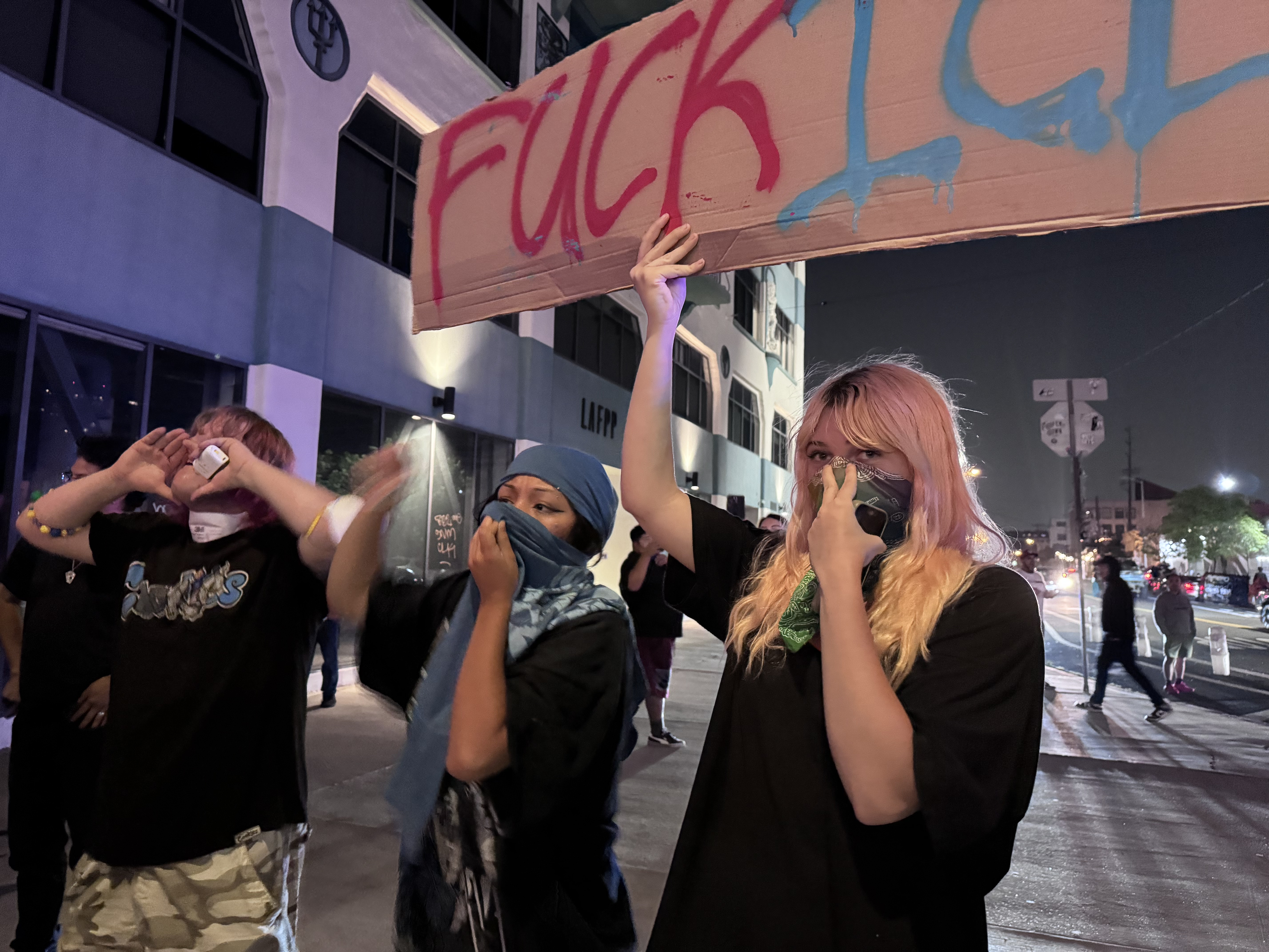 Woman holding FUCK ICE sign