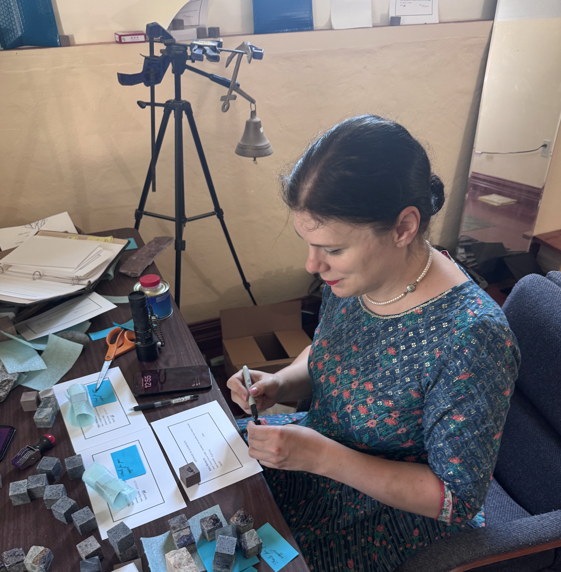Kala sitting at table signing rocks