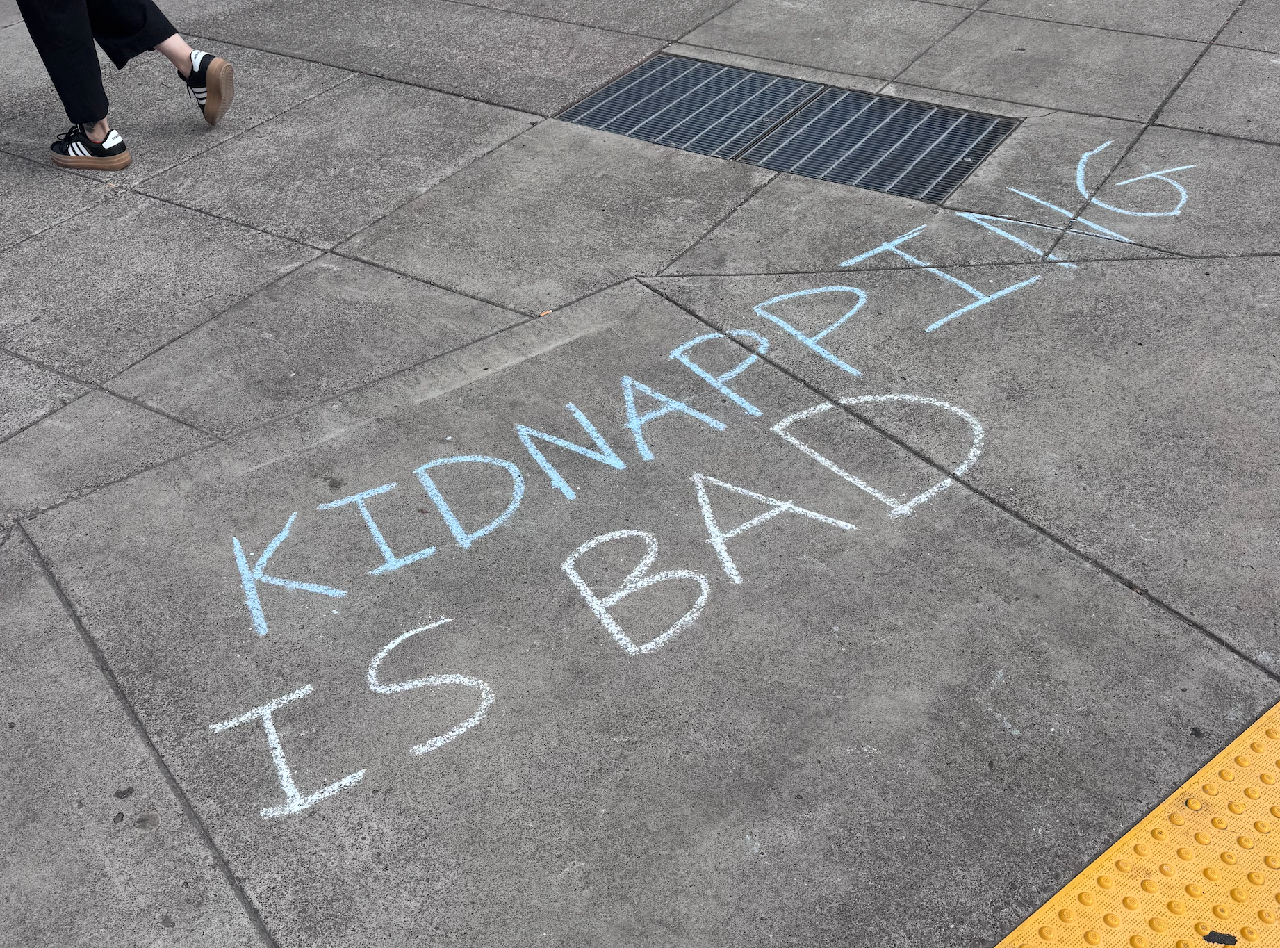Kidnapping is bad" in chalk on the ground