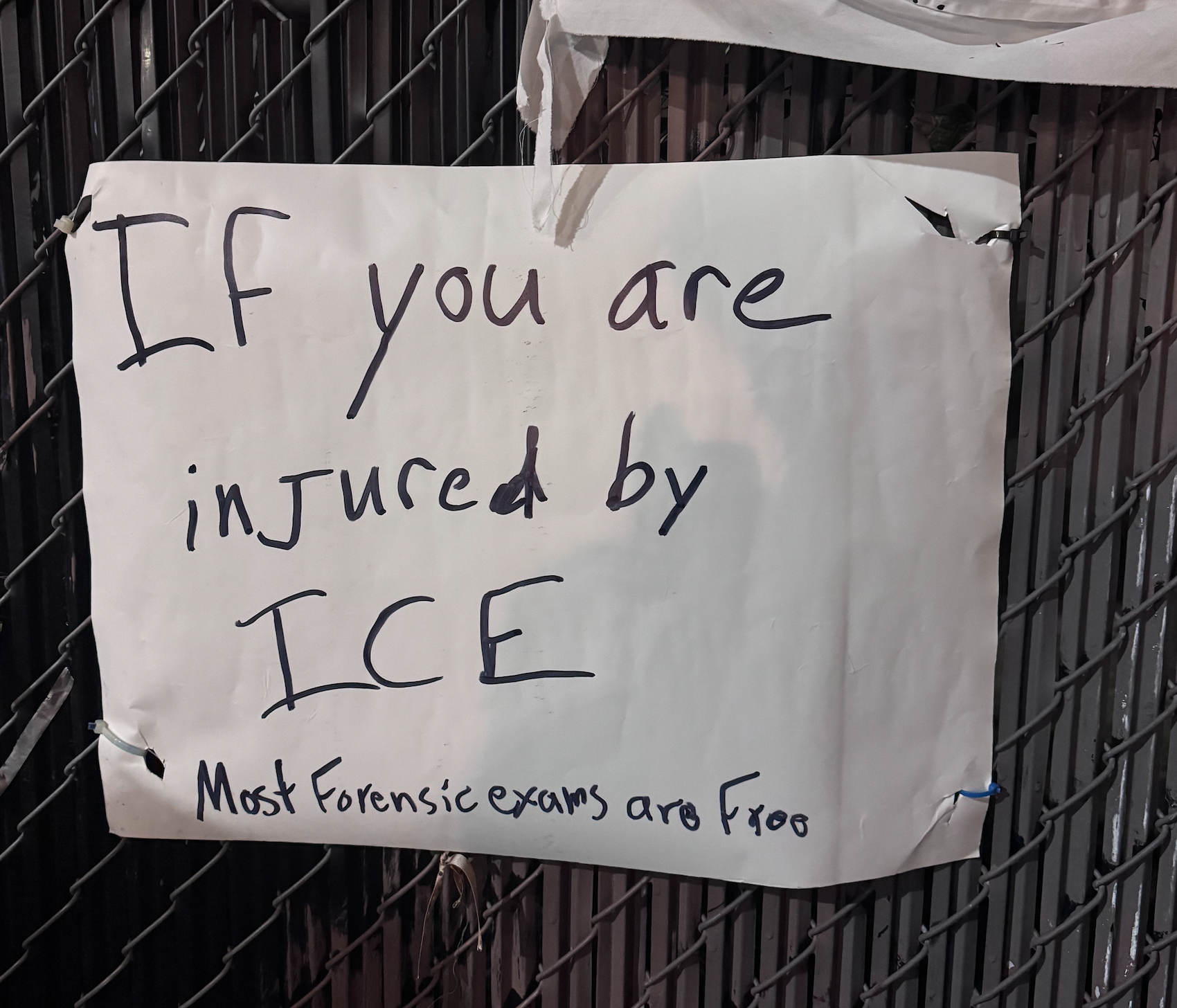 A sign outside ICE: If you are injured by ICE most forensic exams are free