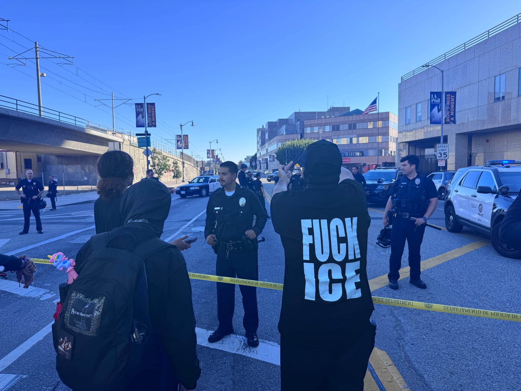 Cops standing in front of Metro Detention Centre while protestor gives them the fingers