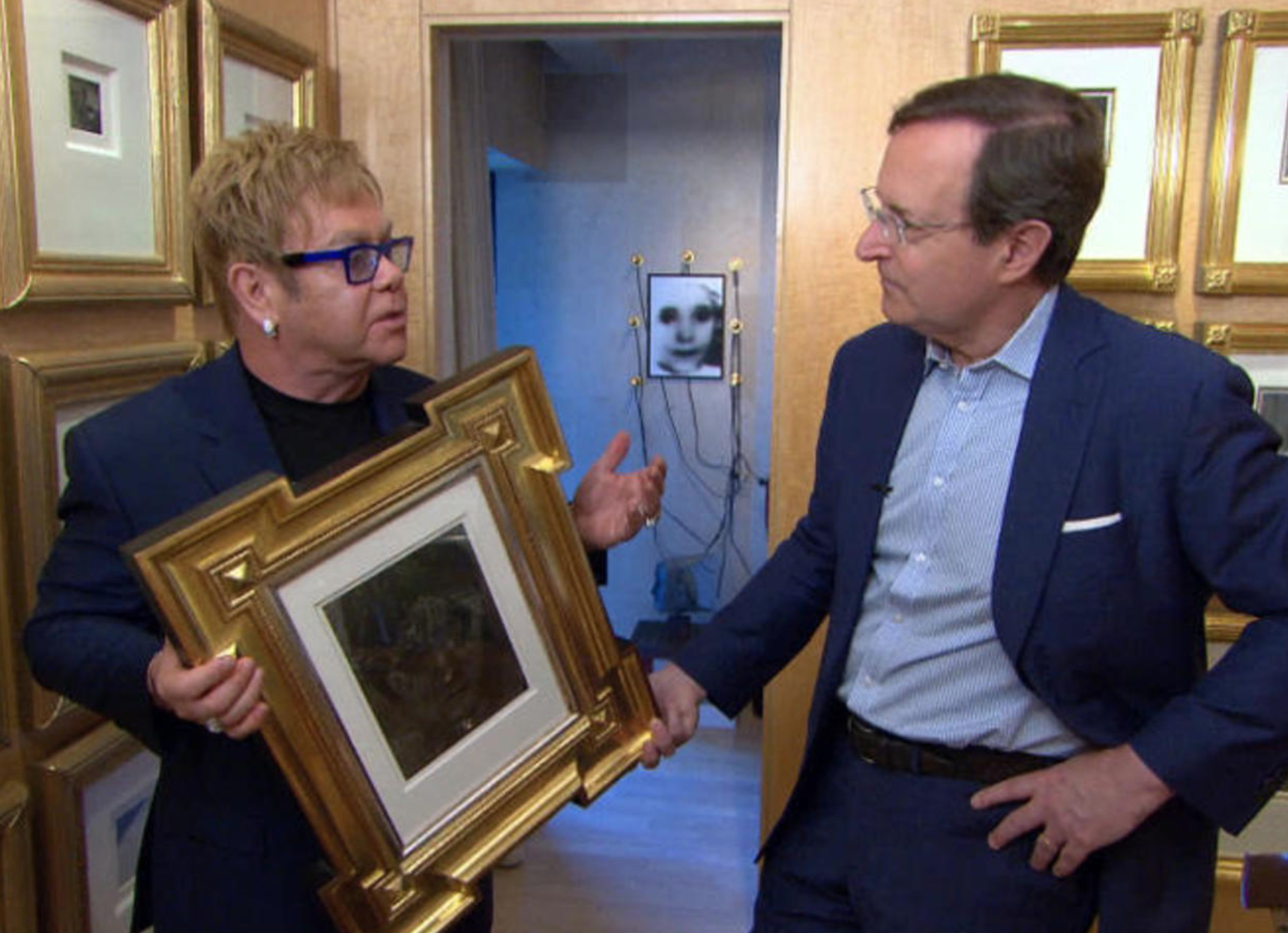 Elton John holding some art