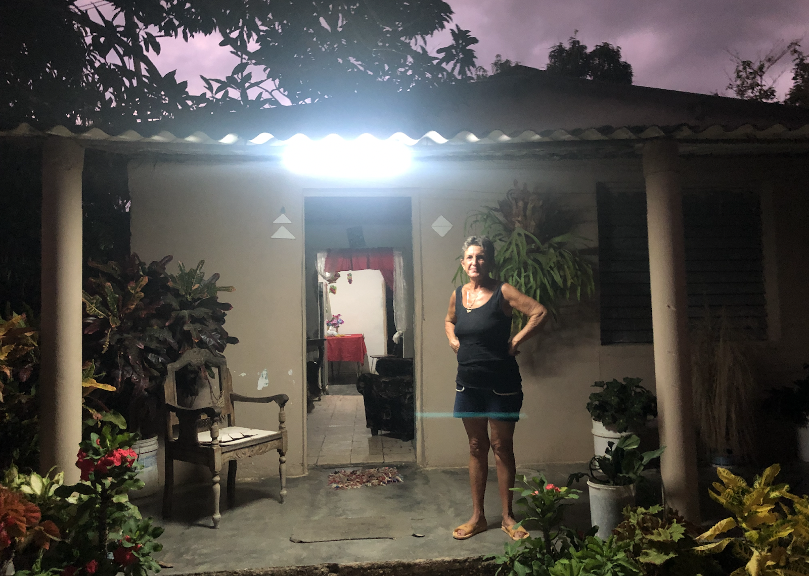 Woman standing on her porch in a singlet and shorts