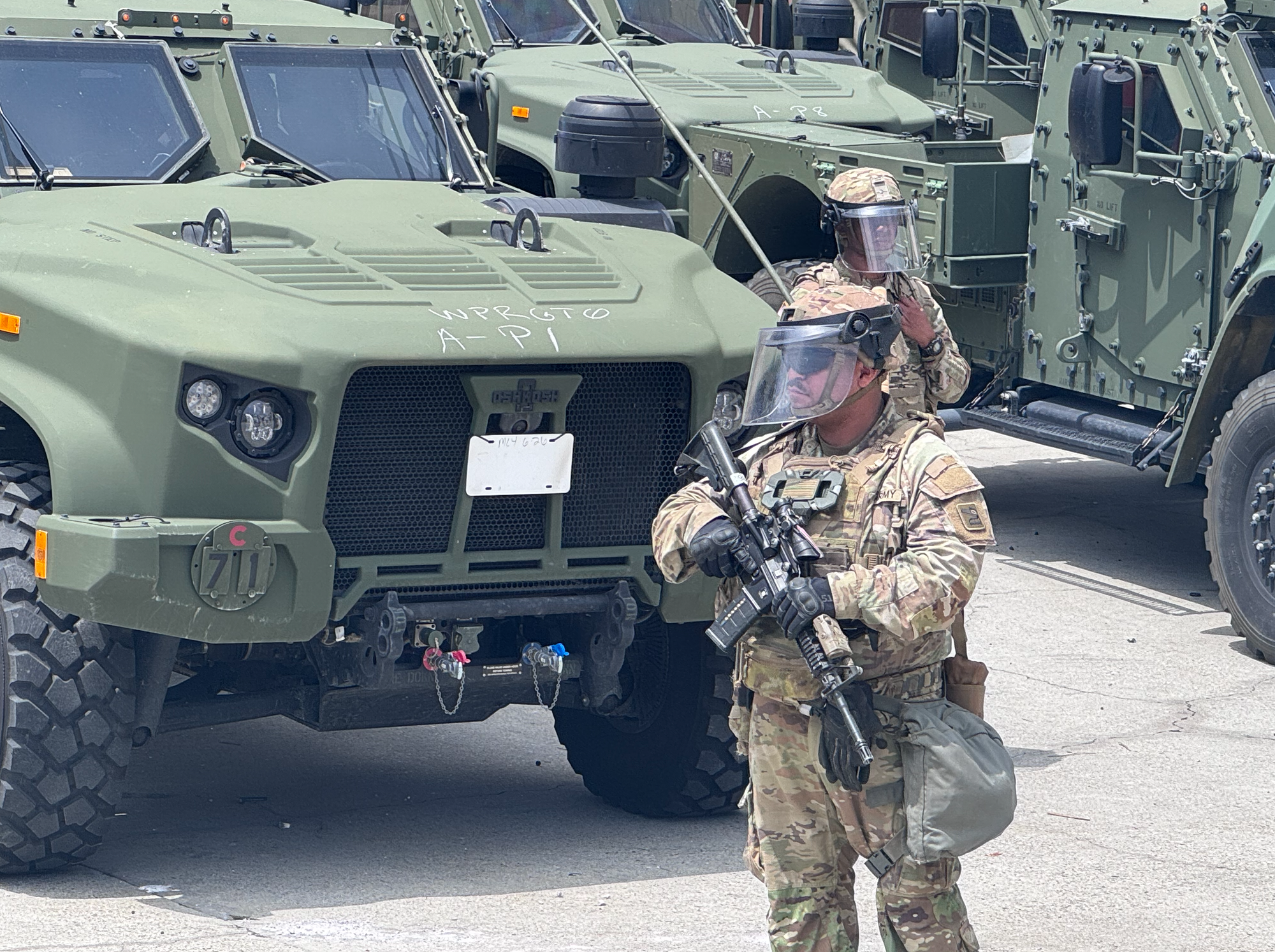 National guard with gun in front of armored vehicle