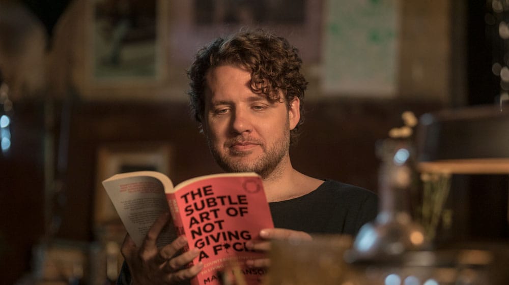 A man reading the Subtle Art of Not Giving a Fuck in the trailer for the film of the same name!