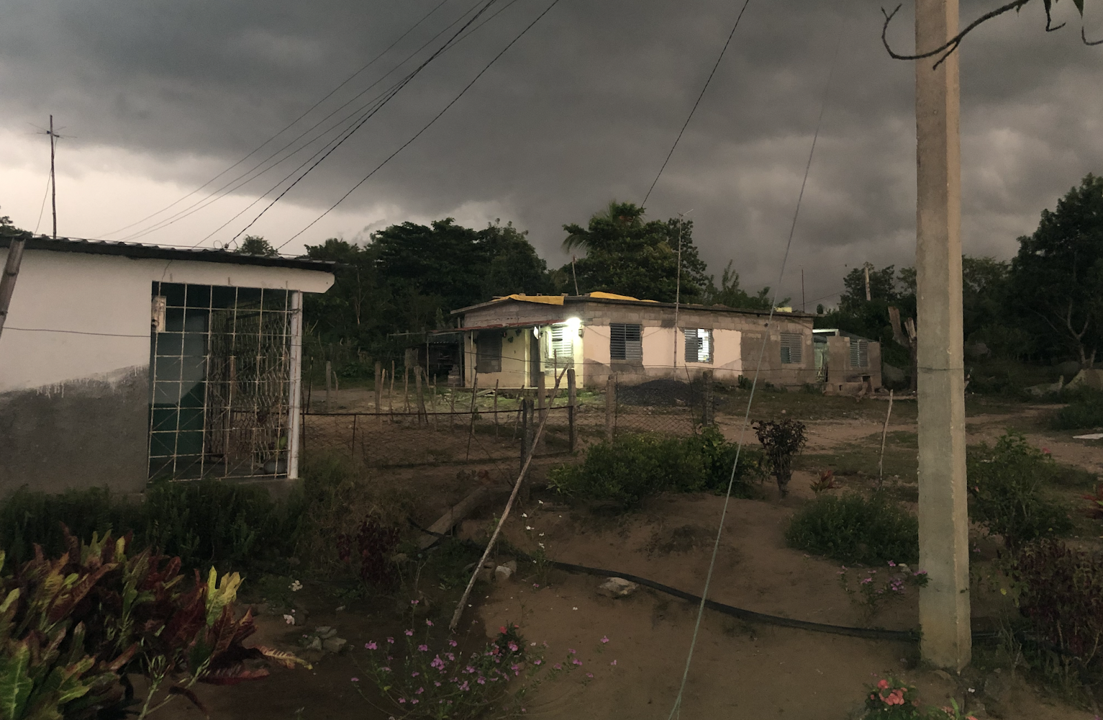 A house and garden, fluro lights blazing into the night