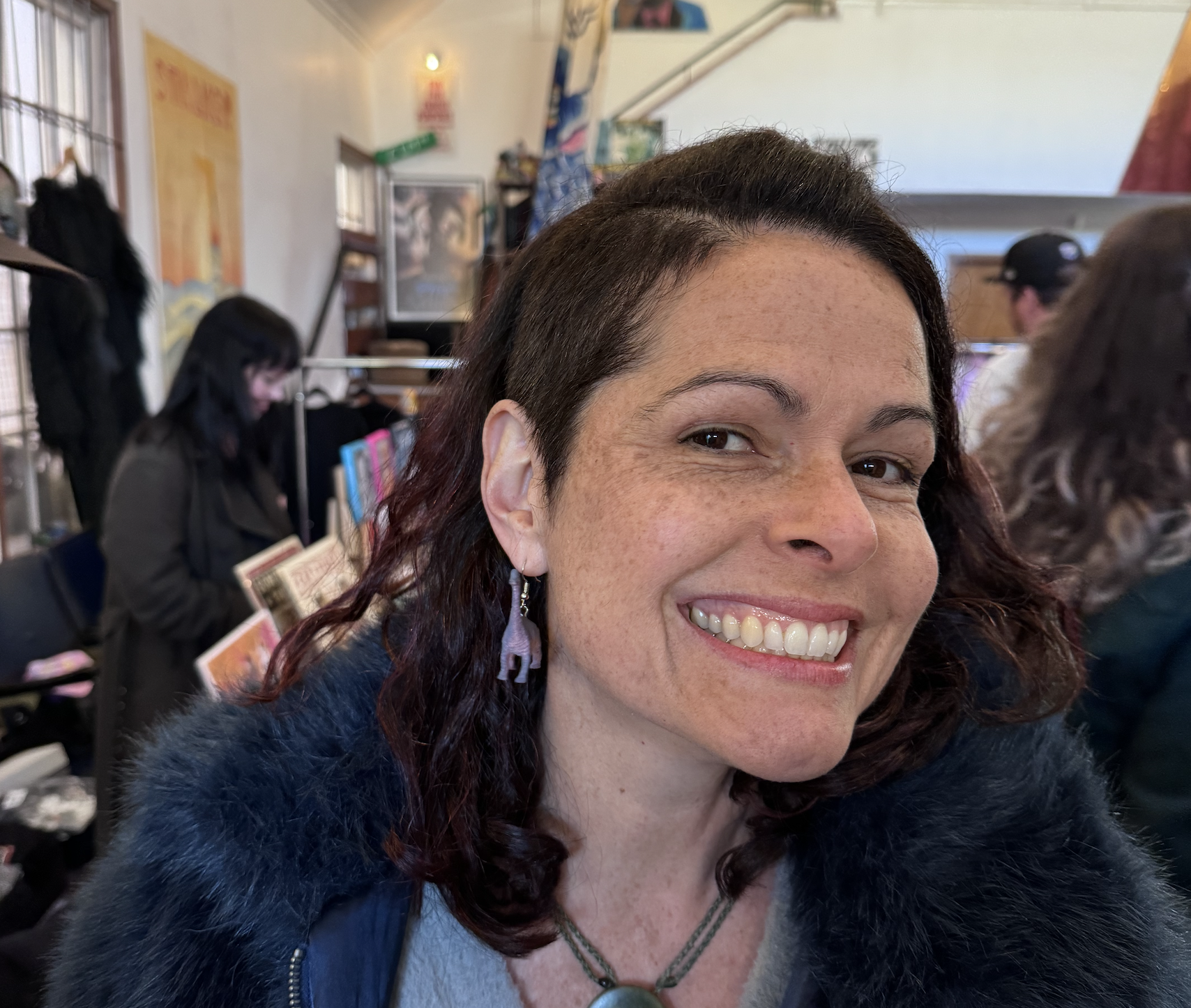 Smiling Webworm reader with dinosaur earrings
