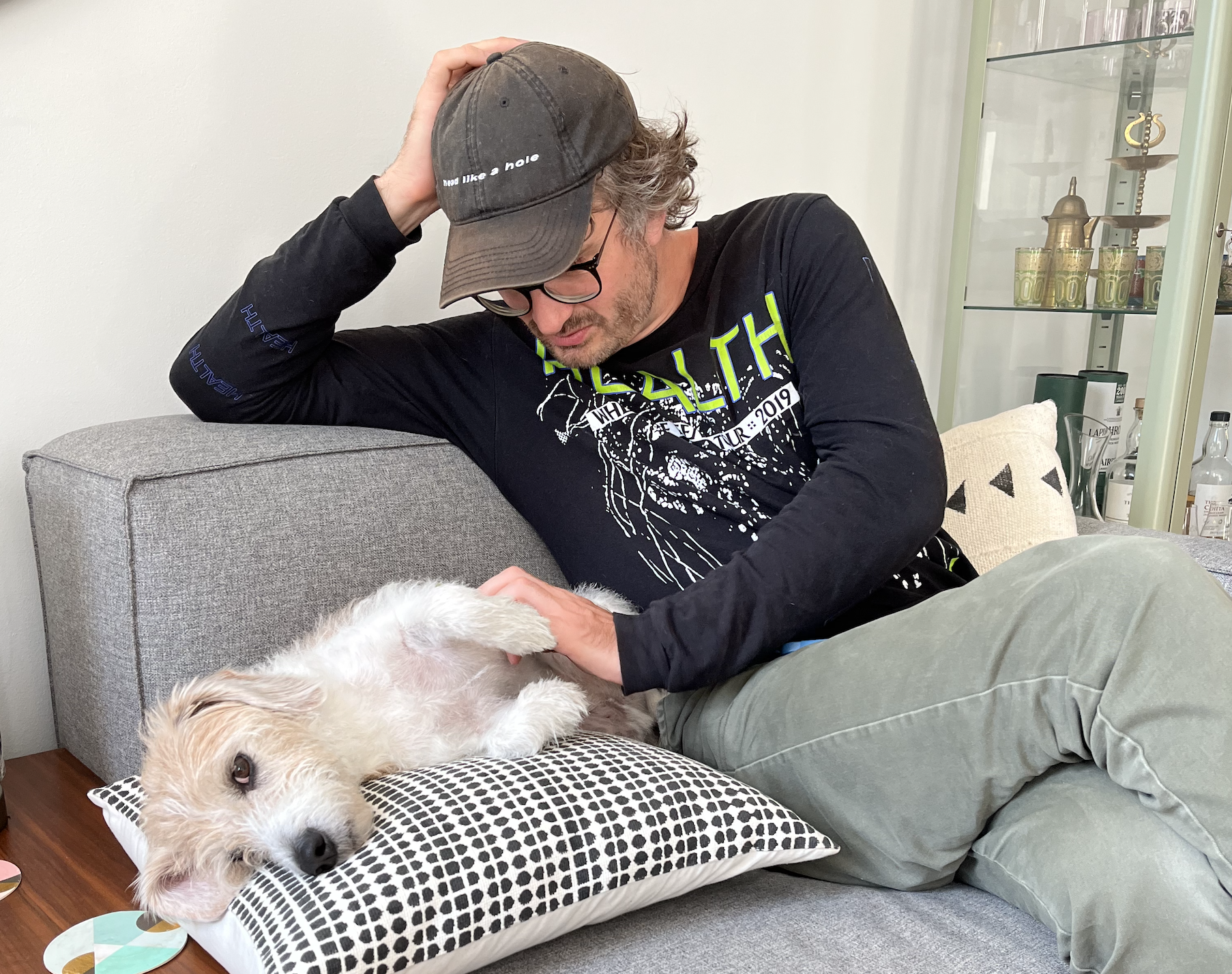 Me on a couch with Buddy, a little scruffball of a dog