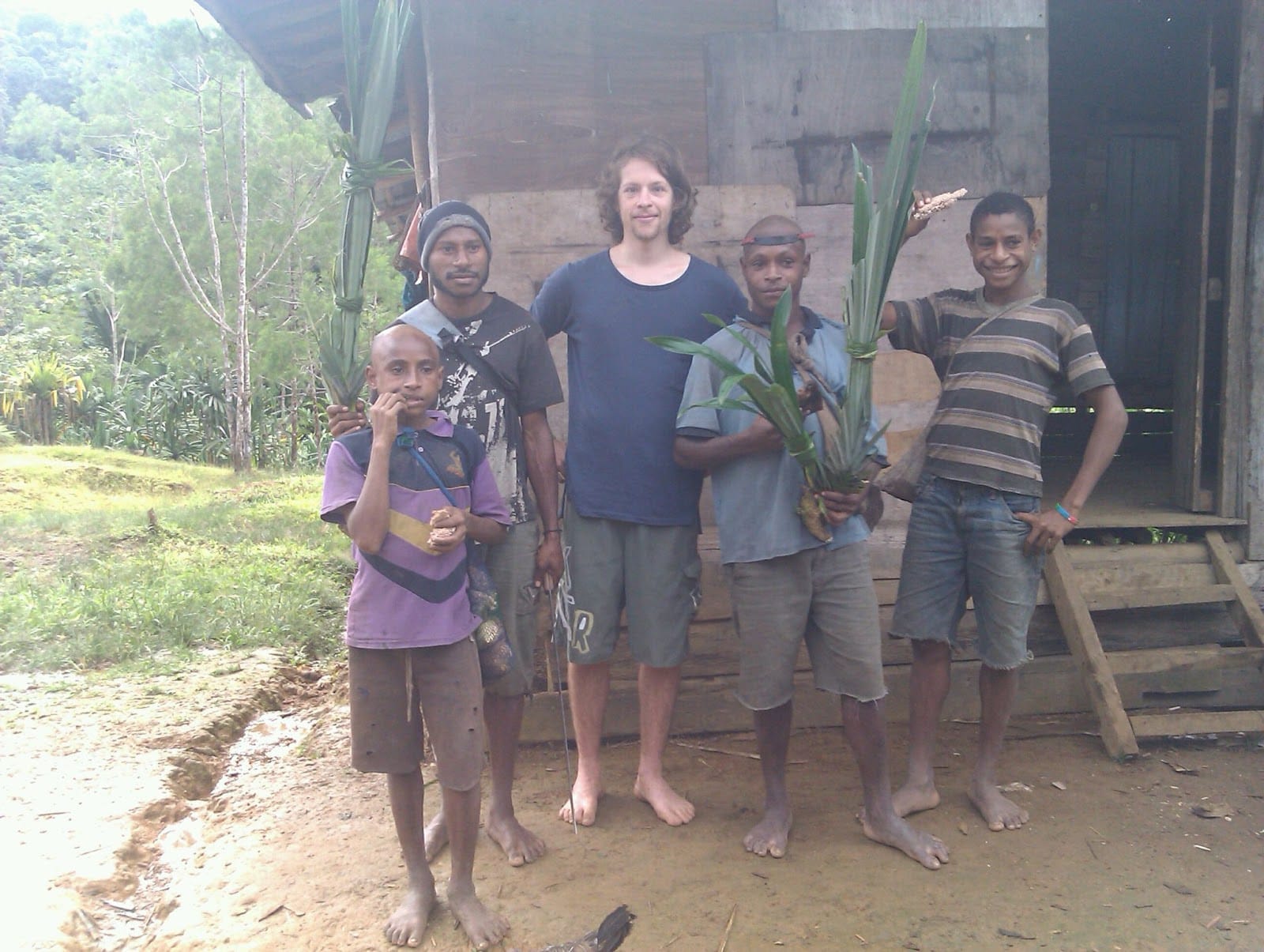 Matt standing with some PNG locals, posing to camera.