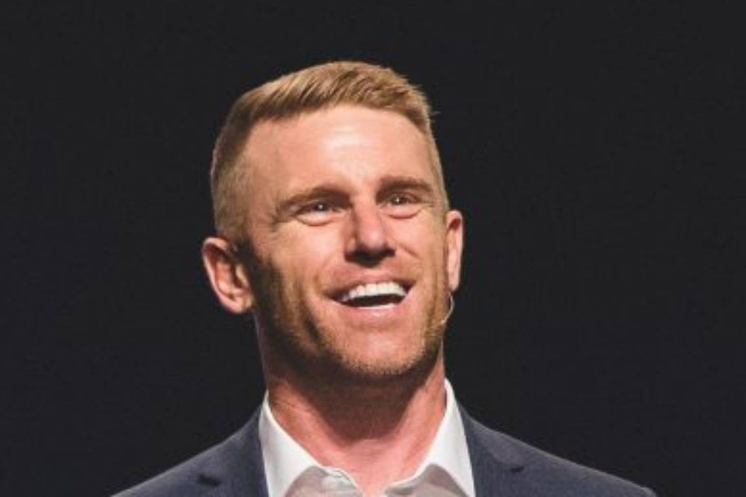 John Cameron smiling on stage at Arise