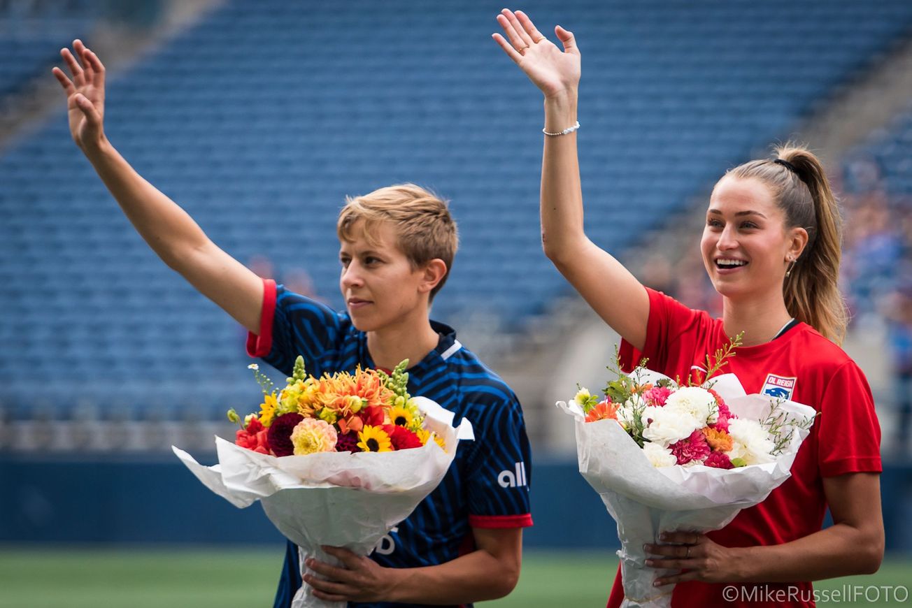 Quinn and Jordyn Huitema receive flowers in recognition of their World Cup pahead of an OL Reign game.