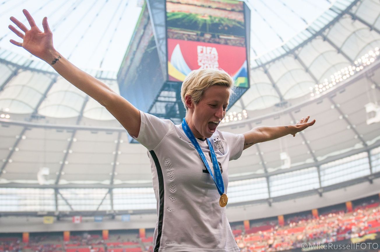 Megan Rapinoe spreads her arms wide, celebrating the 2015 World Cup win.