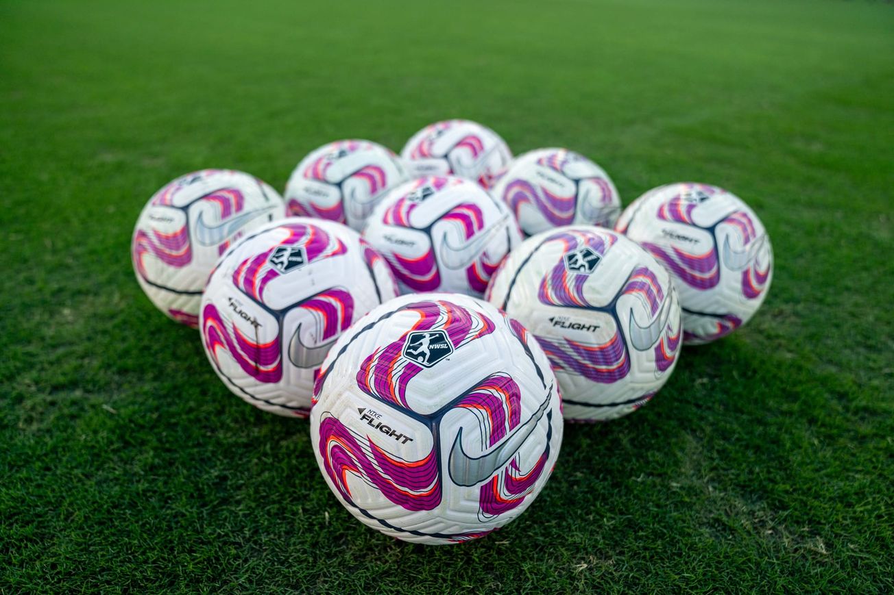 A collection of NWSL soccer balls in a diamond shape.