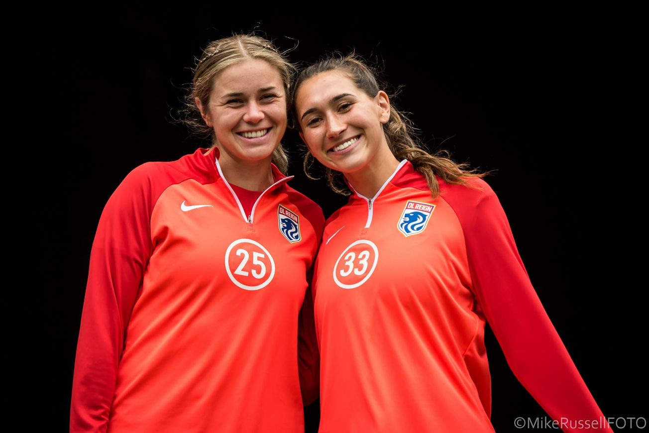 UW alumni Shae Holmes and Olivia Van der Jagt pose together ahead of a 2023 Reign match.