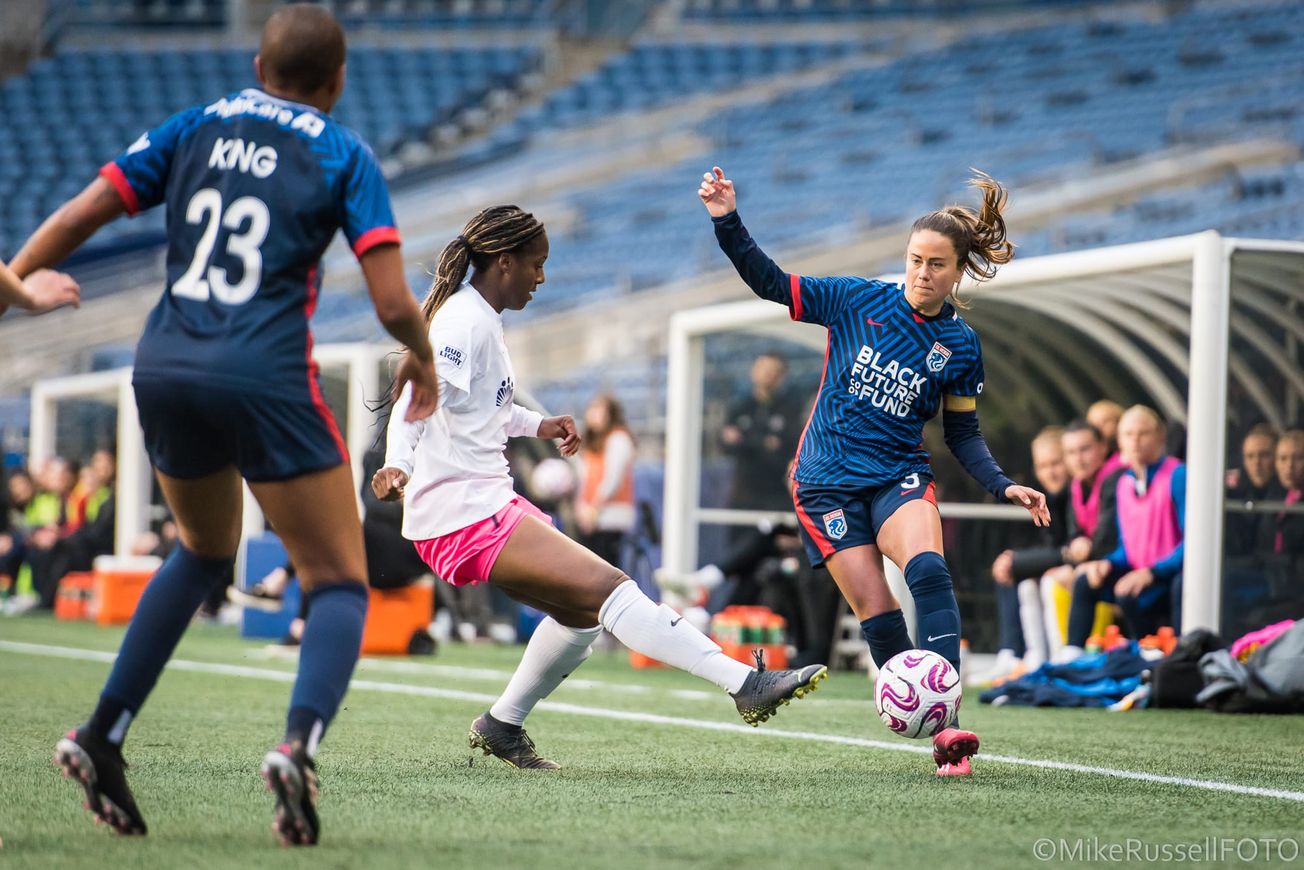 Lauren Barnes of the Reign attempts to pass the ball to Tziarra King during a match against SD Wave in 202