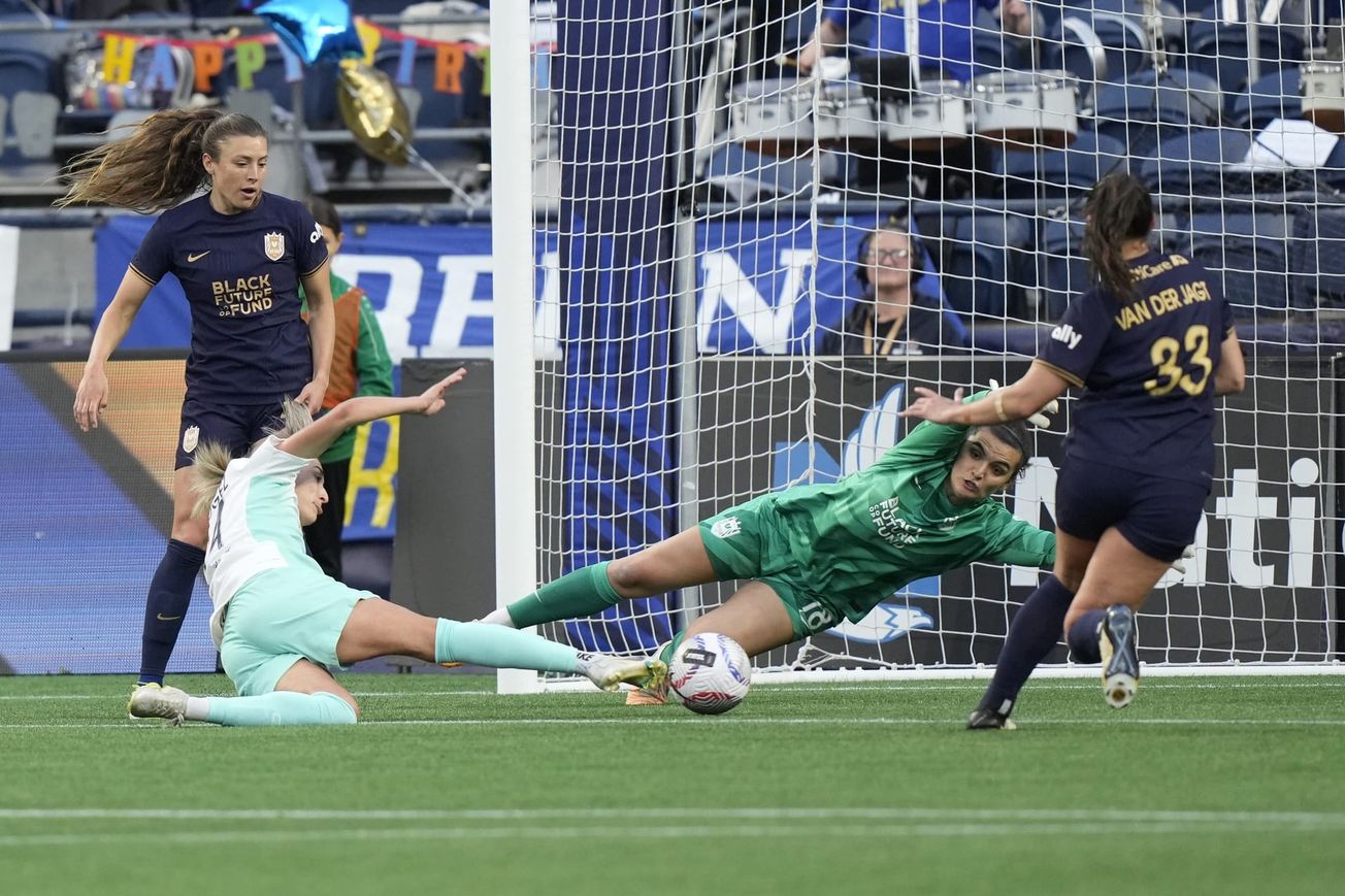 Seattle Reign goalkeeper Laurel Ivory dives to block a shot in a game against the Kansas CIty Current in May 2024.