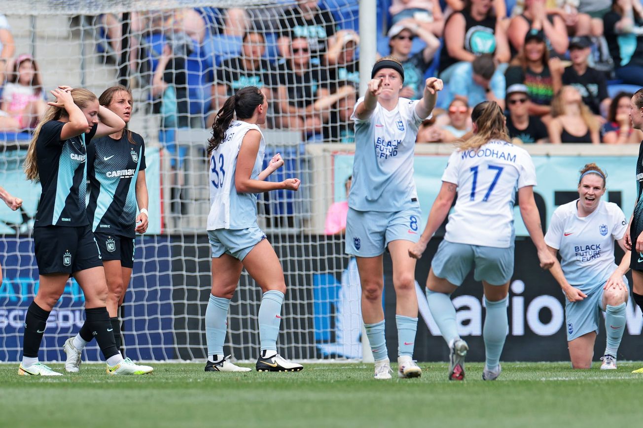 Reign forward Bethany Balcer gestures toward Quinn (outside of view) after the team scored a late goal against Gotham FC.