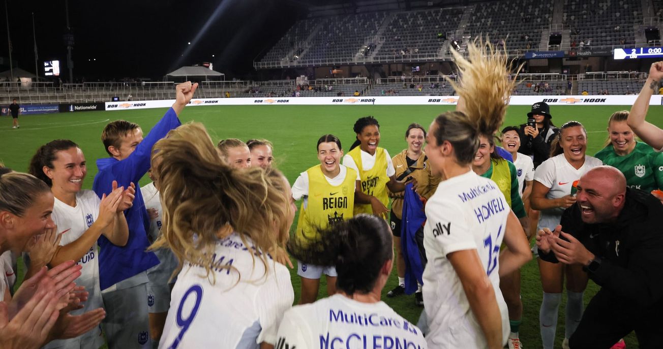 Seattle Reign players celebrate a win over Racing Louisville in an NWSL game.