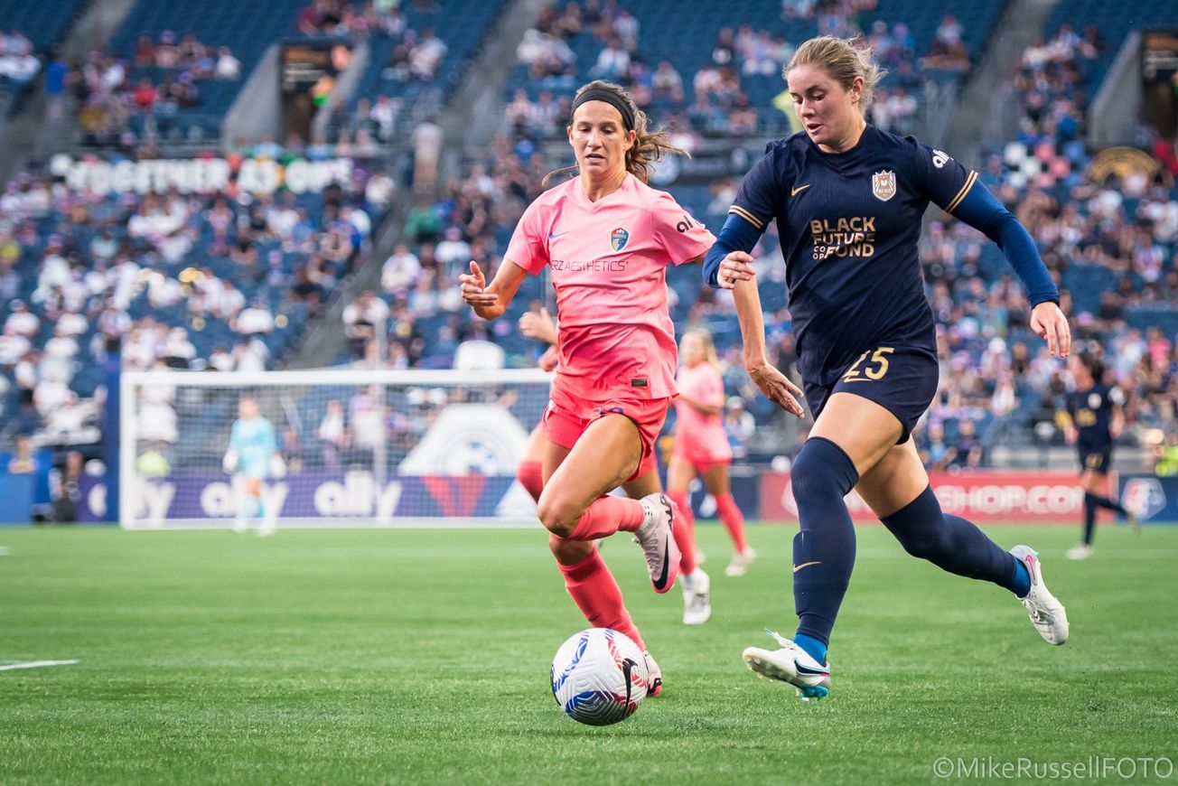Seattle Reign FC defender Shae Holmes dribbles past a North Carolina Courage player.