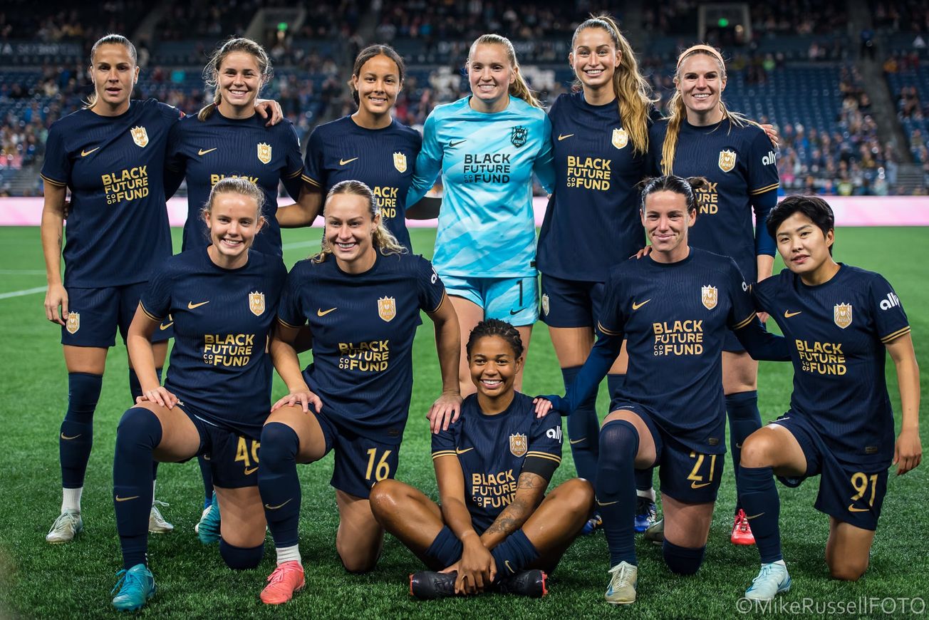 The Reign lineup smiles for a group photo before having very little to smile about in an Oct 2024 game vs. Angel City FC.