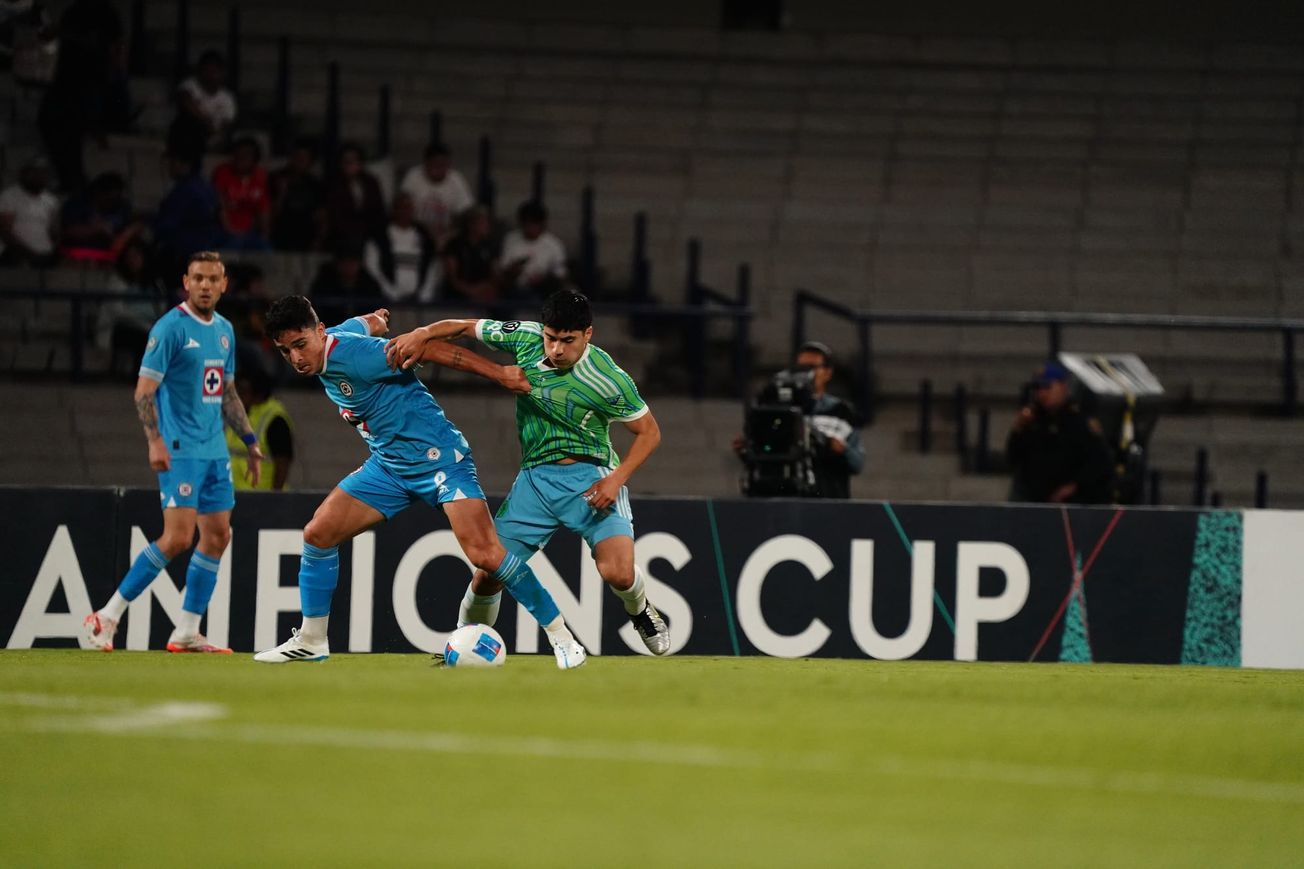 Obed Vargas has his jersey pulled as he fights for the ball with a Cruz Azul player.