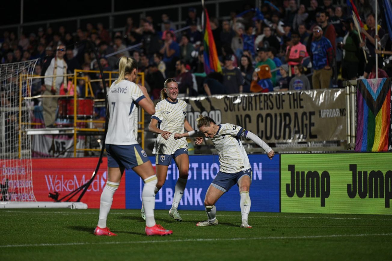 Jess Fishlock celebrates a goal against NC Courage with Ana-Maria Crnogorcevic and Maddie Dahlien.