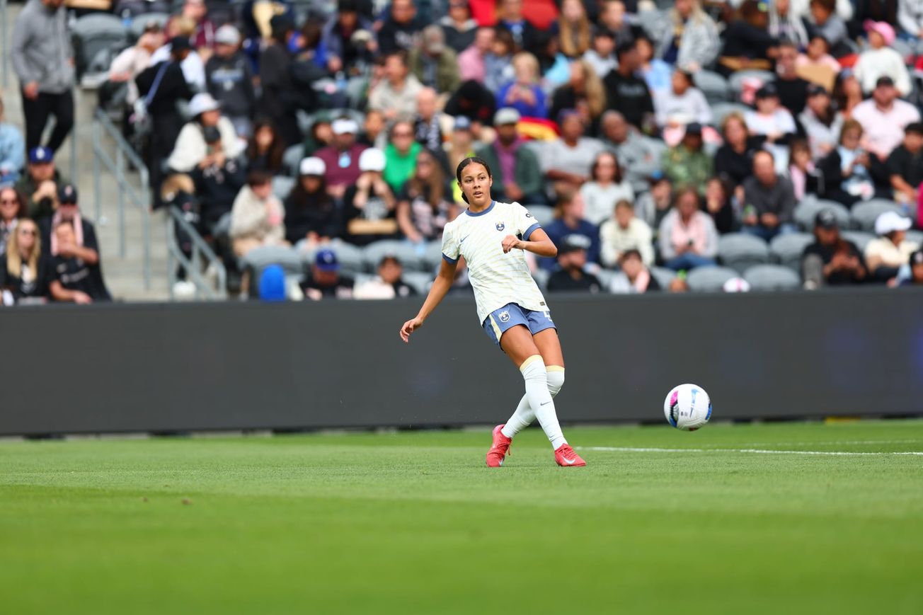 Reign defender Jordyn Bugg strikes a pass in a game against Angel City FC in March 2025.