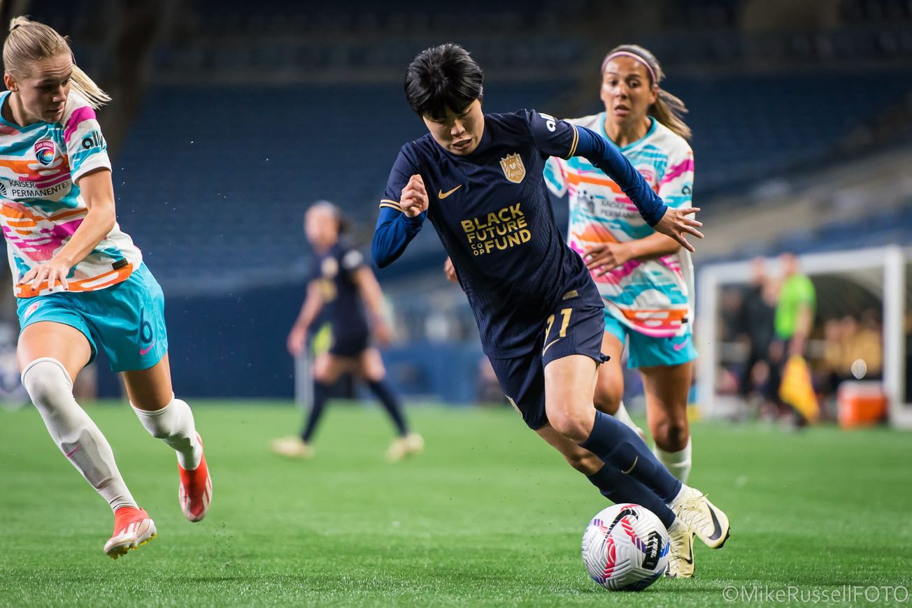 Reign midfielder Ji So-yun dribbles against the San Diego Wave in a May 2024 match.