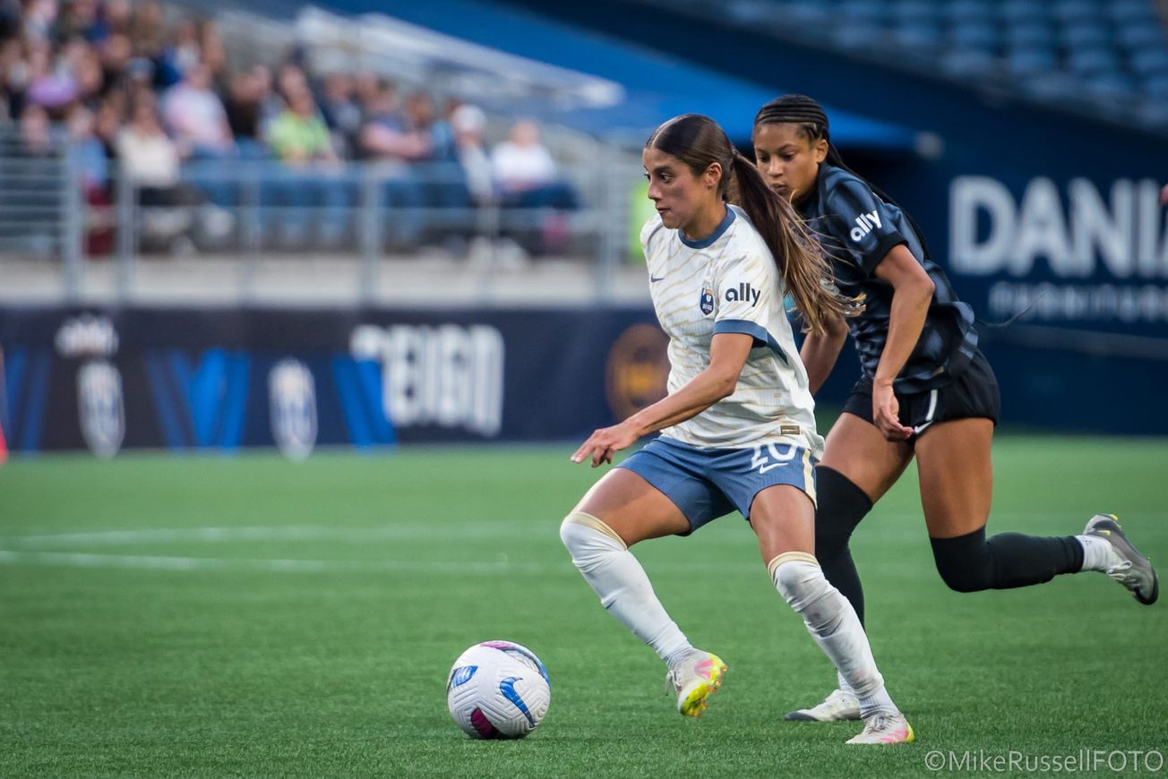 Reign midfielder Sam Meza dribbles against the Washington Spirit in a May 2025 match at Lumen Field.