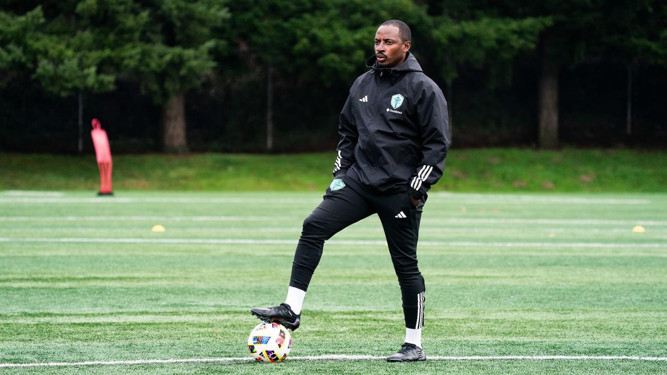 Former Defiance Head Coach Herve Diese standing in all black with a soccer ball.