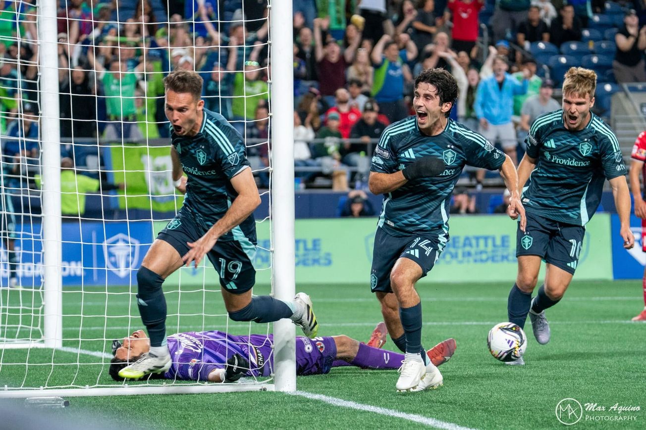 Danny Musovski, Paul Rothrock and Pedro de la Vega celebrate while the GK lies on the floor.