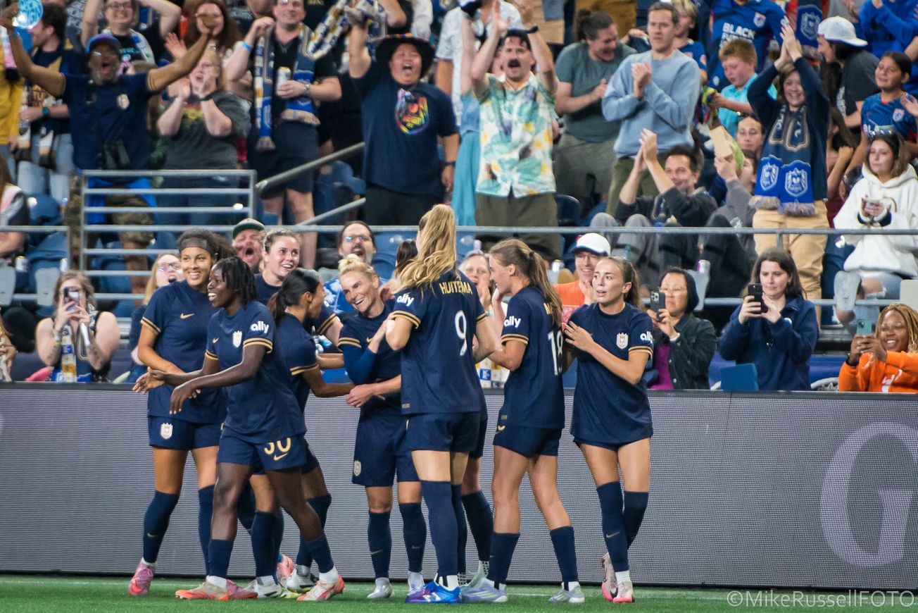 Seattle Reign players celebrate a Jess Fishlock goal against Angel City FC in August 2025.