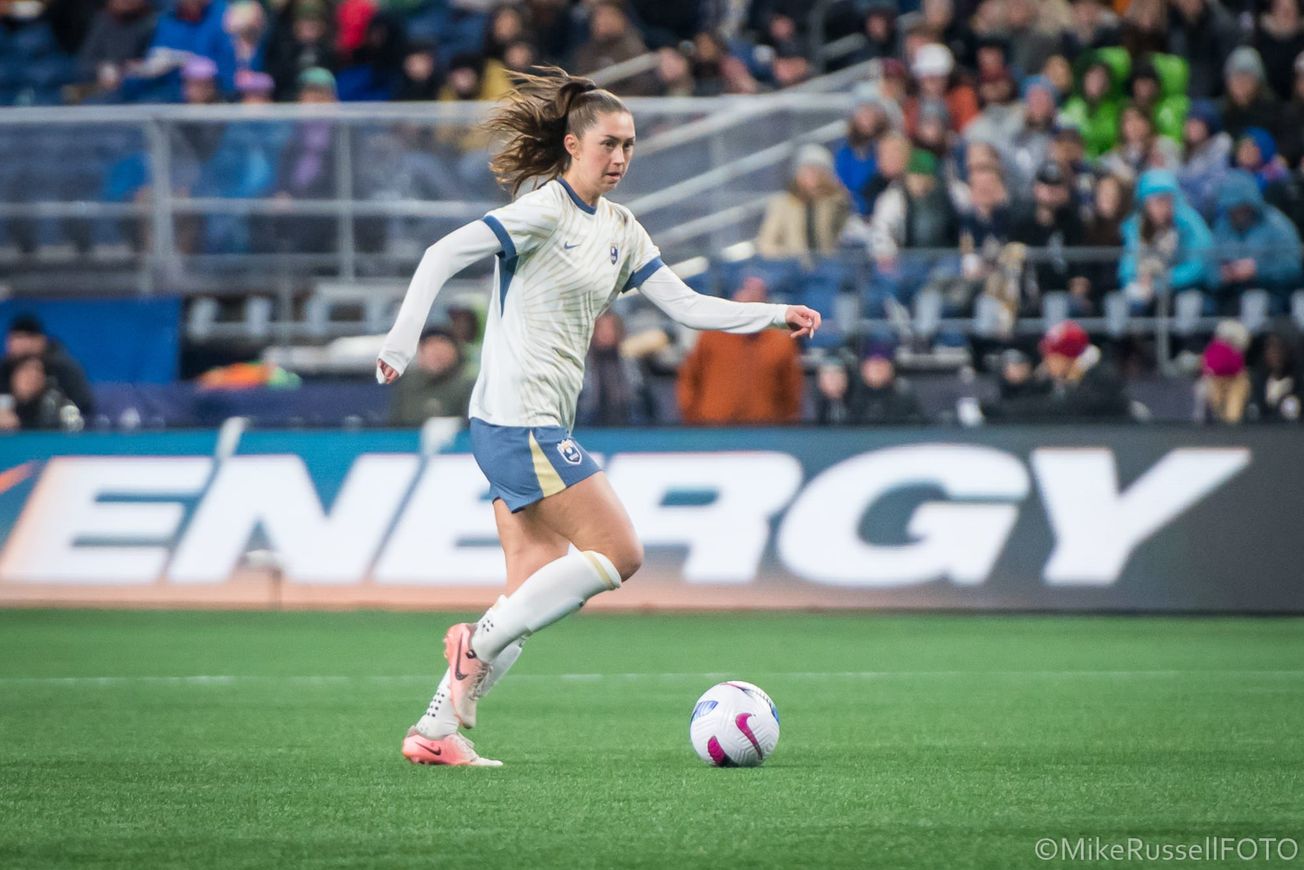 Reign midfielder Maddie Mercado dribbles in a March 2025 game against Gotham FC at Lumen Field.