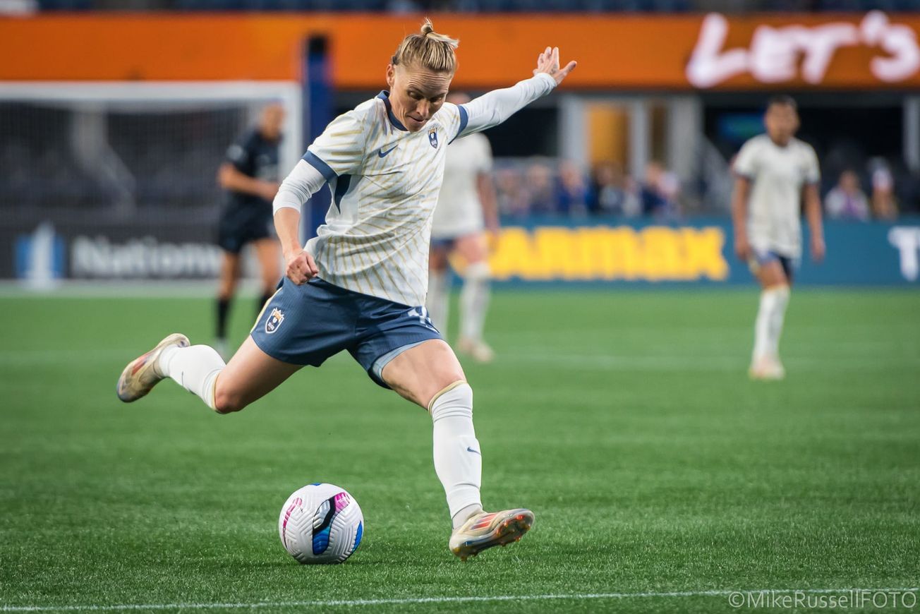 Reign midfielder Jess Fishlock winds up to shoot against the Washington Spirit in a May 2025 match at Lumen Field.