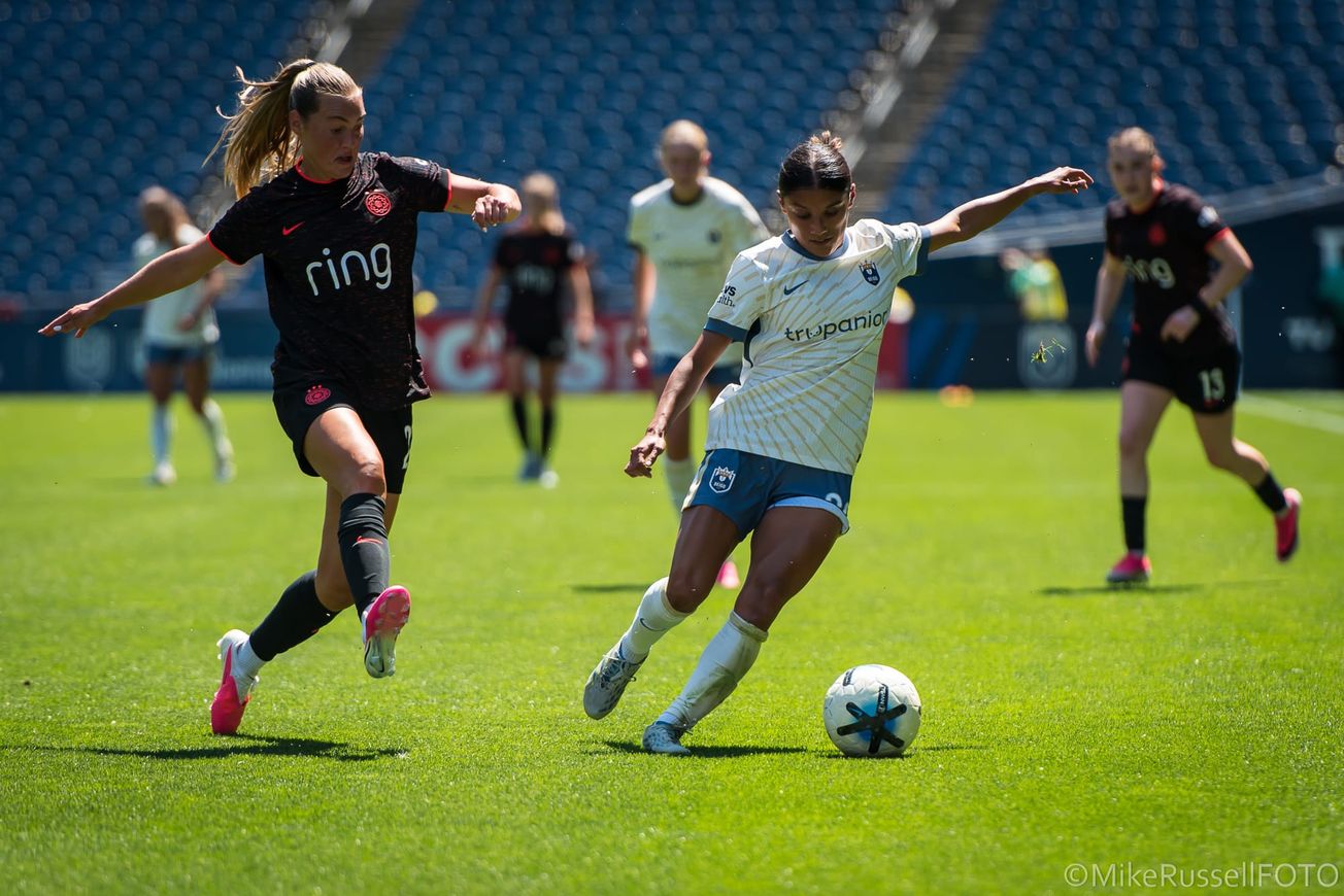 Seattle Reign’s Sam Meza shields the ball from a Portland Thorns player in a July 2026 match.