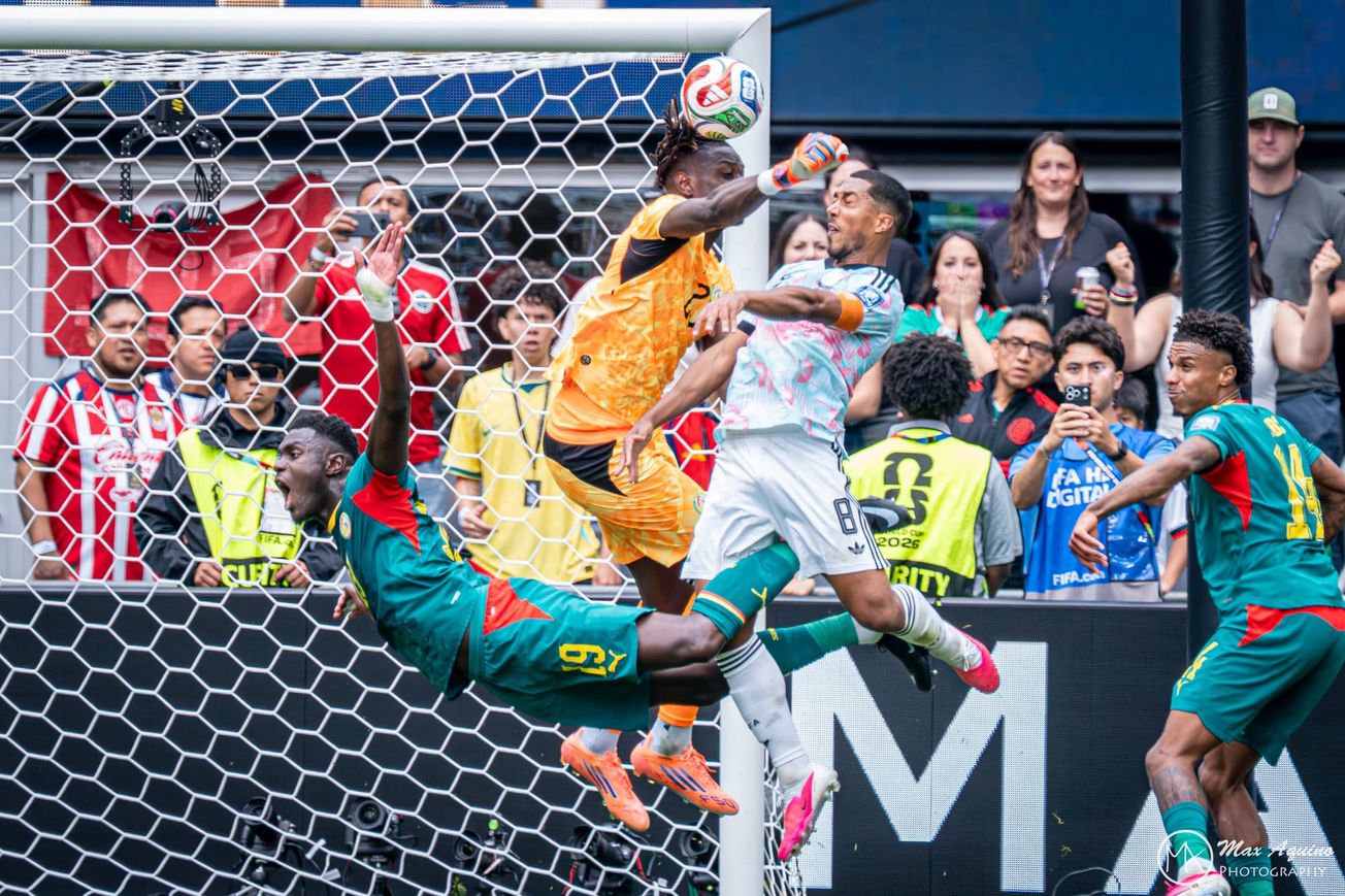 Youri Tielemans in a white, light blue and pink Belgium jersey heads the ball past goalkeeper Mory Diaw in an orange kit.