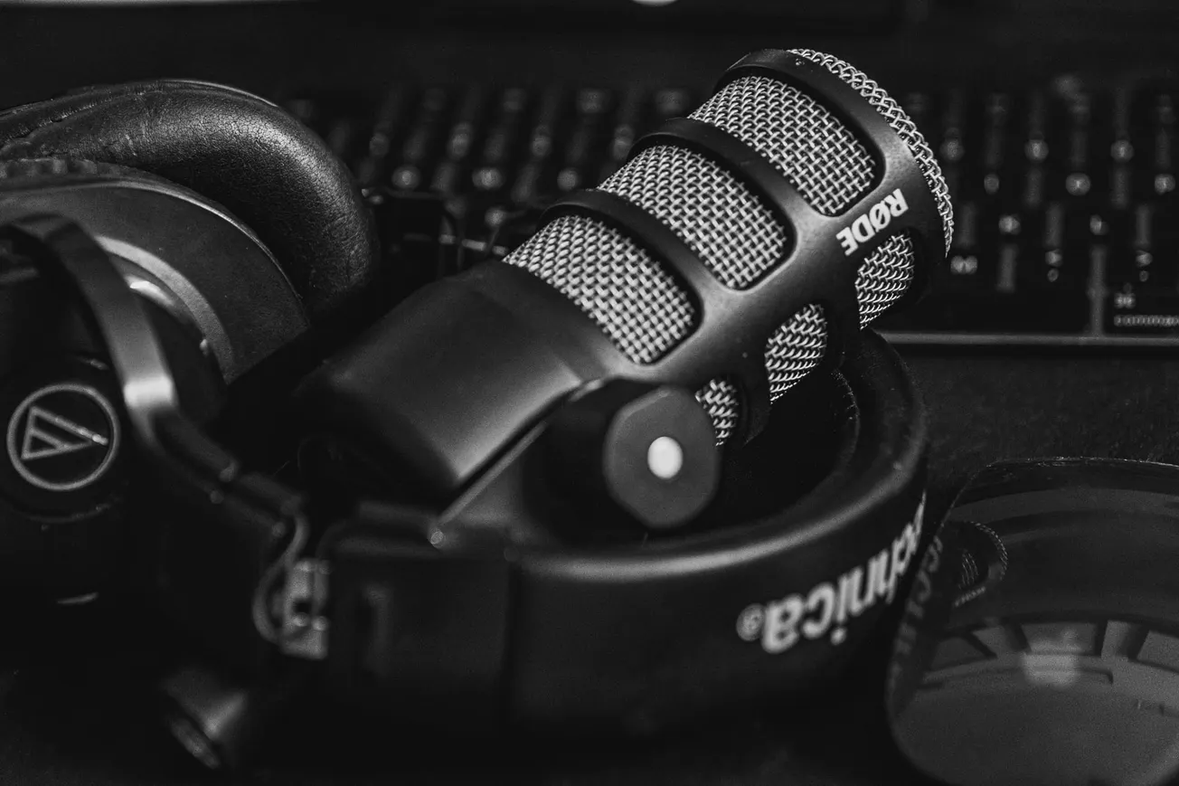 A microphone and headphones resting next to a mouse and a keyboard.