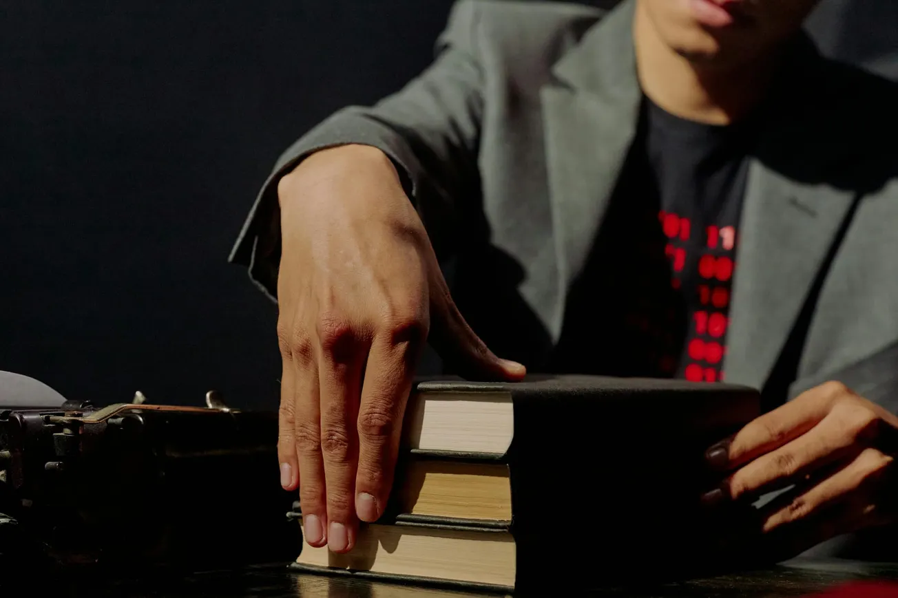 Close up on mans hands placing books on table