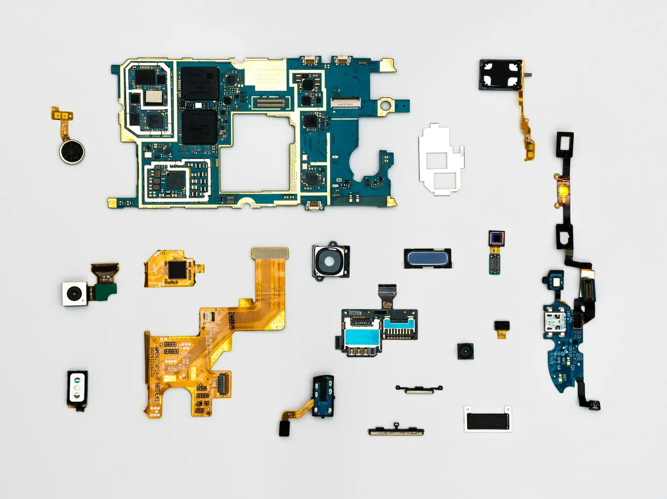 An array of disassembled smartphone components on a white background, including circuit boards, camera modules, and connectors, showcasing intricate electronics.