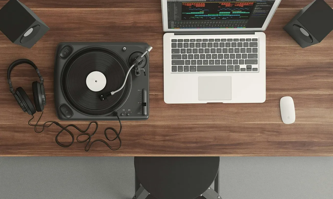 A wooden desk with a turntable, headphones, and a laptop showing audio software. Speakers are placed on either side, conveying a music production setup.
