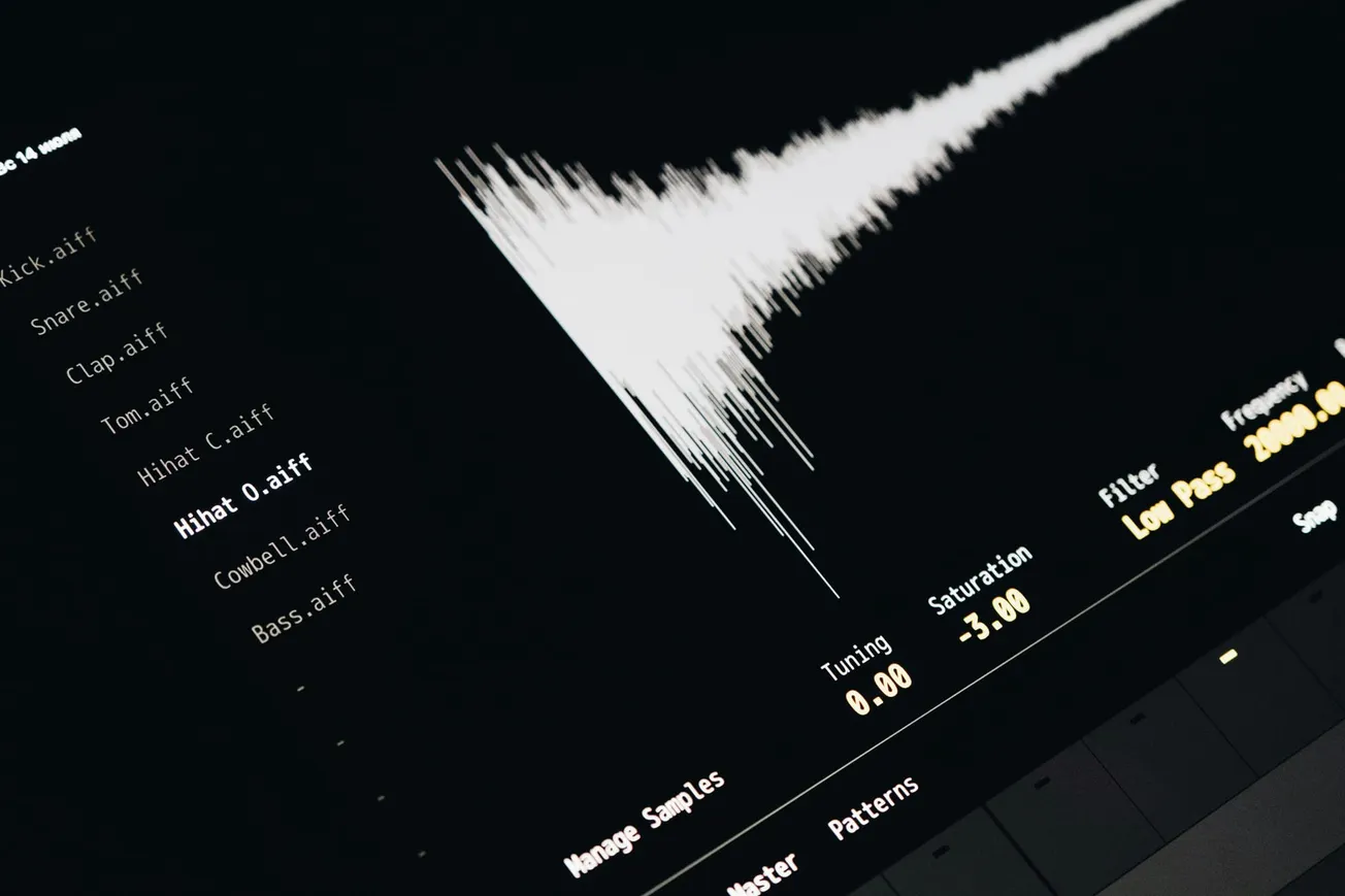 Close-up of a digital audio interface displaying a waveform on the right and a list of sound files on the left. The mood is technical and focused.