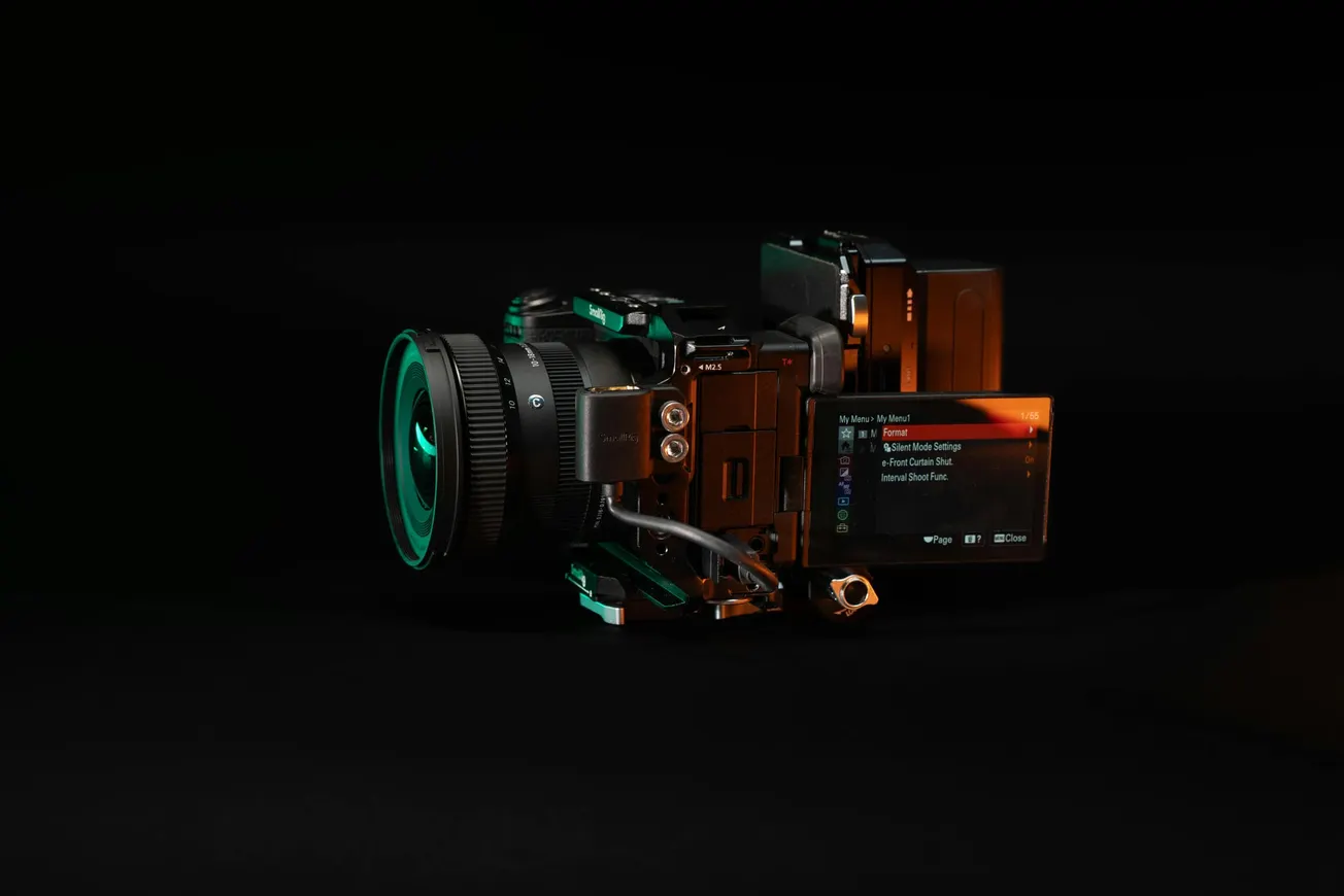 Sleek camera with a visible screen displaying menu options, and attached lens, set against a dark background. Modern and professional appearance.